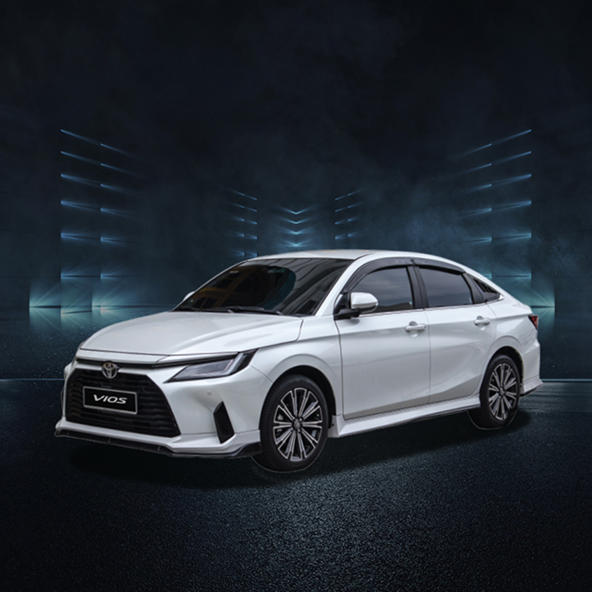 White Toyota Vios sedan with sleek design and alloy wheels, studio front-side view.