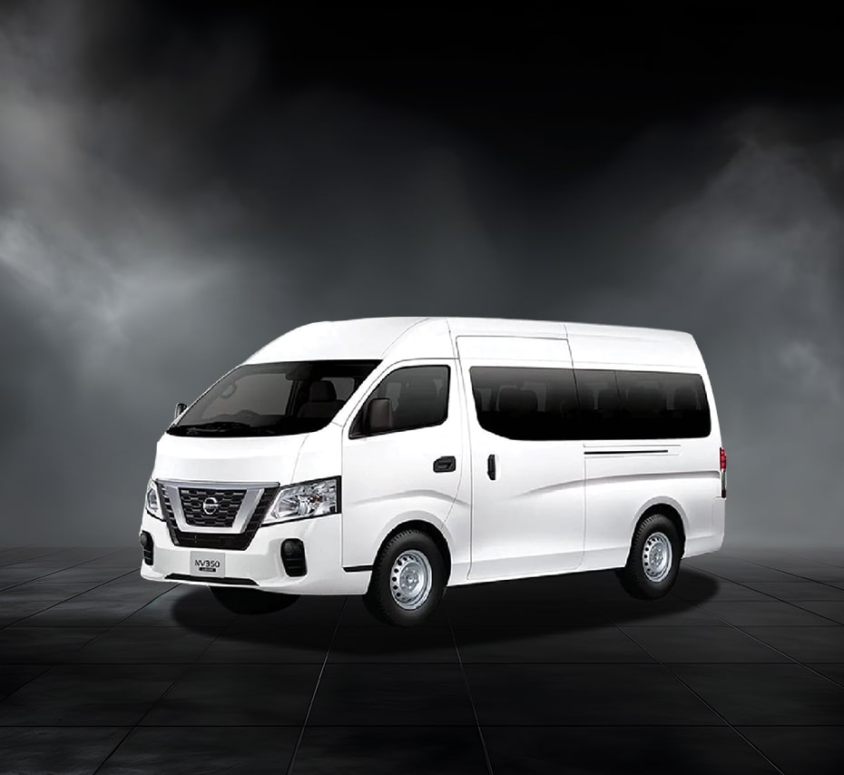 White Nissan NV350 high-roof passenger van with tinted windows on a dark studio background.