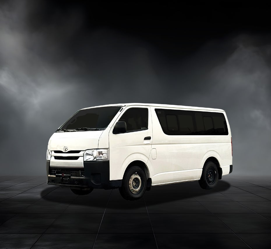 White Toyota Hiace passenger van with tinted windows on a dark studio background.