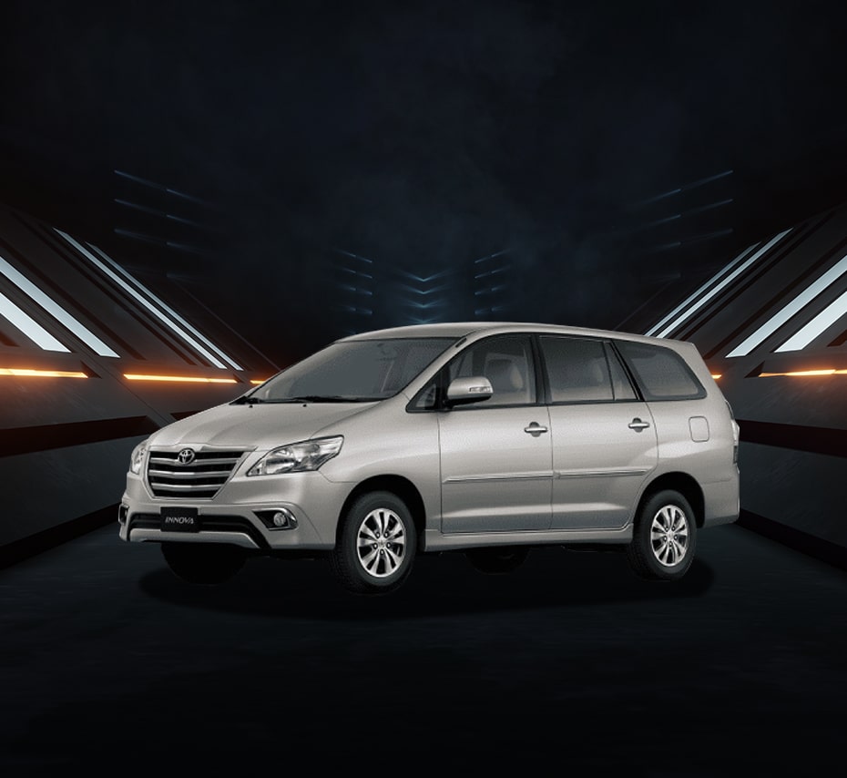 Silver Toyota Innova MPV with chrome grille and alloy wheels, studio front-side view.