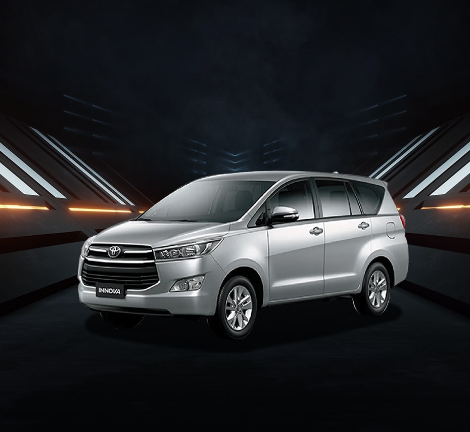 Silver Toyota Innova MPV with bold front grille and alloy wheels, studio front-side view.