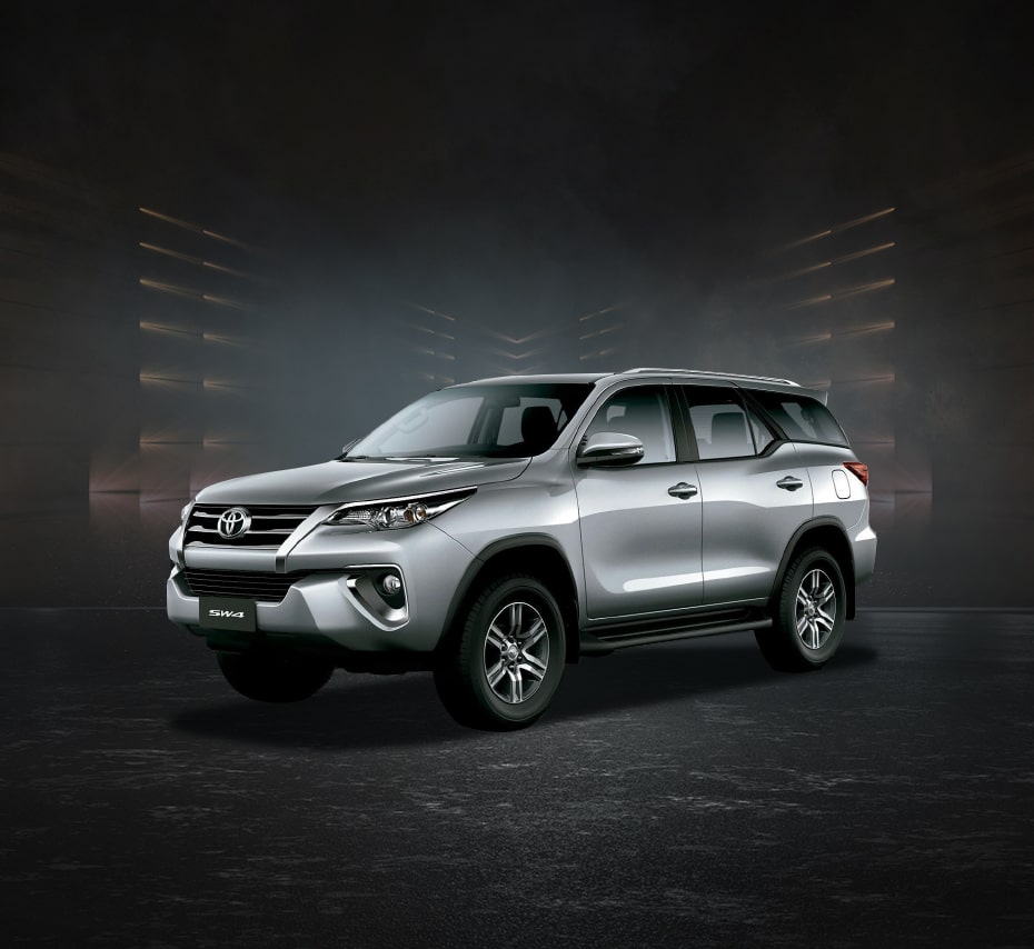 Silver Toyota Fortuner SW4 SUV with sleek headlights and chrome grille, studio front-side view.